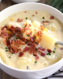 White bowl with potato soup, bacon and chives.