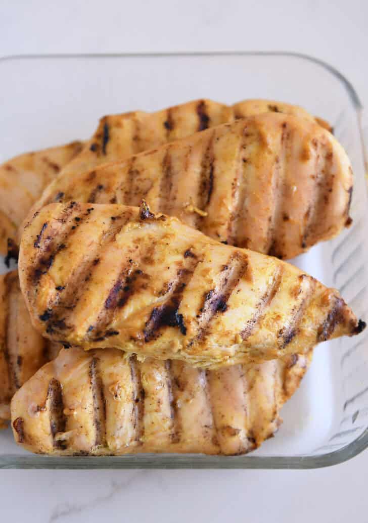 Grilled chicken breasts in glass dish.