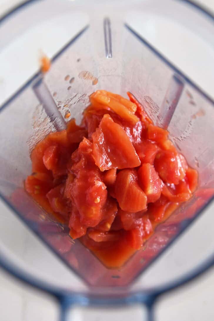 Top down view of blender with diced tomatoes.