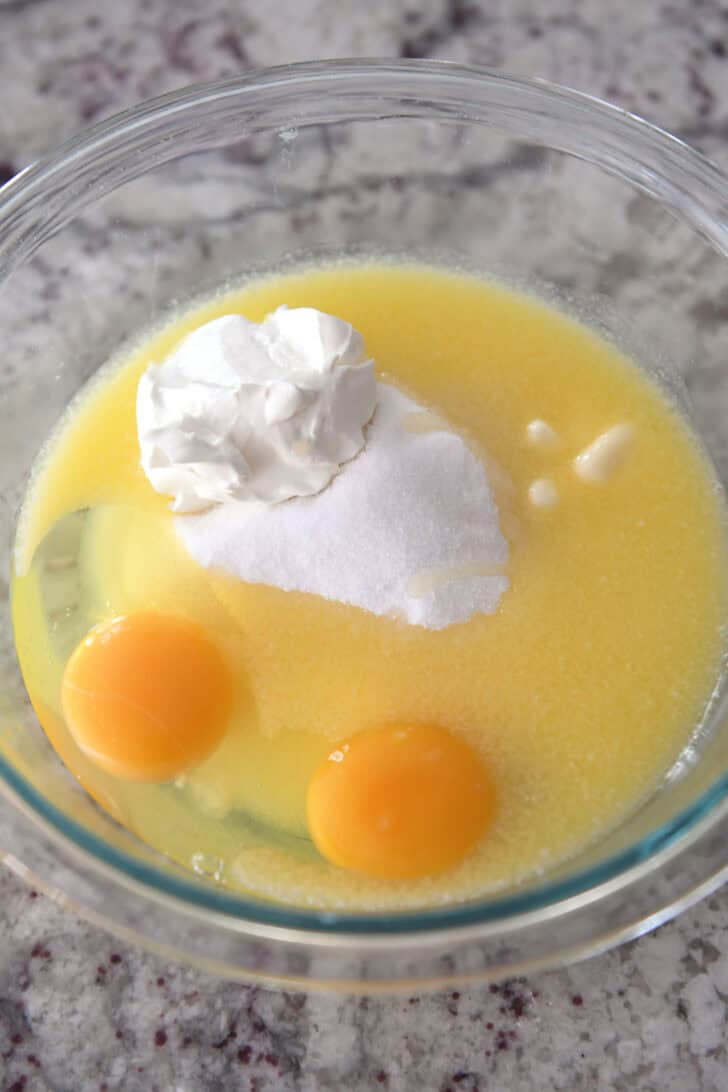 Glass bowl with eggs, sugar, sour cream and butter.