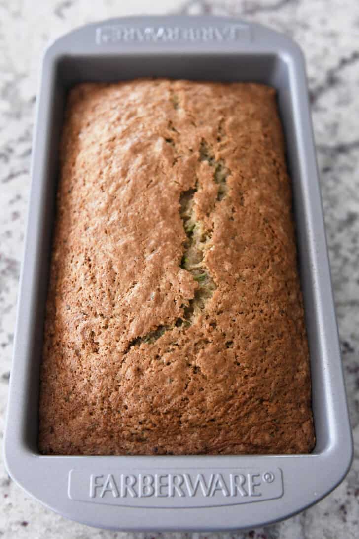 Large loaf pan with baked loaf of zucchini bread.