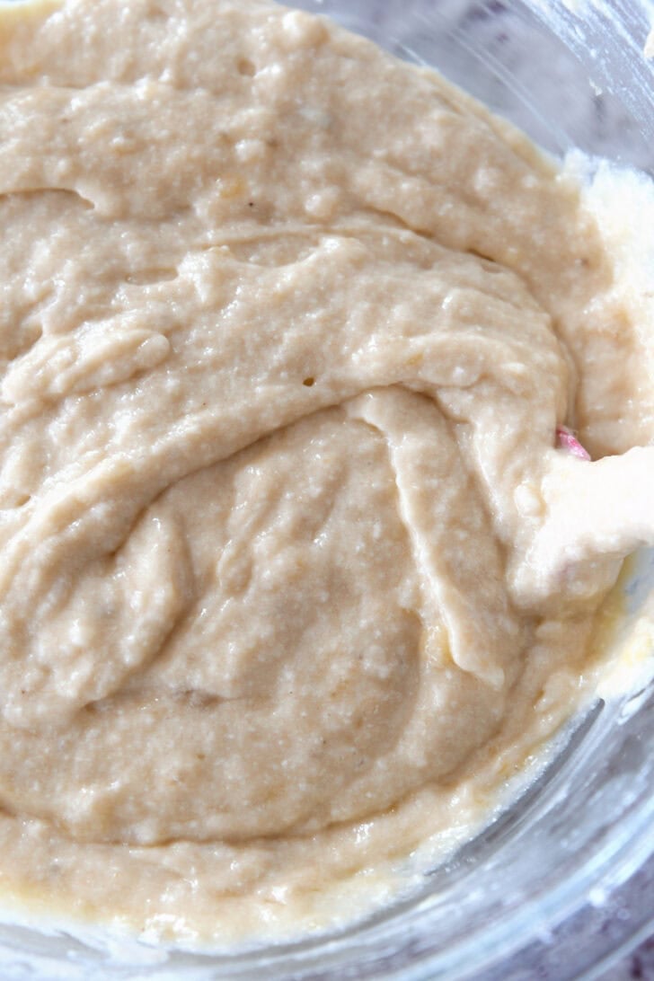 Top down view of banana bread batter being mixed in a glass bowl.