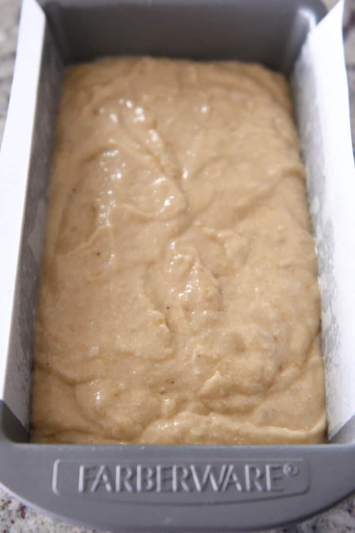 Top down view of banana bread batter in a metal Farberware bread pan.
