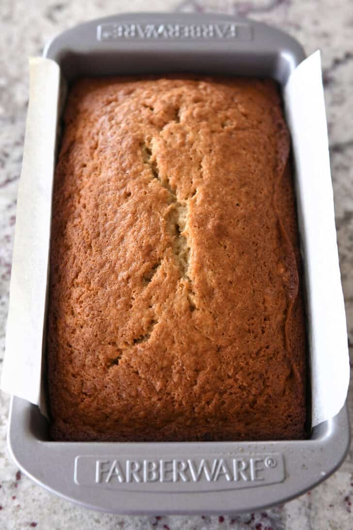 Top down view of a cooked loaf of banana bread in a metal Farberware bread pan.