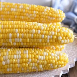 Fresh cooked corn on the cob stacked on top of each other.