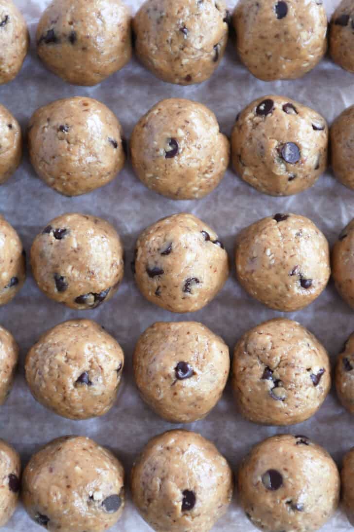 Top down view of chocolate chip peanut butter balls on a sheet of wax paper.