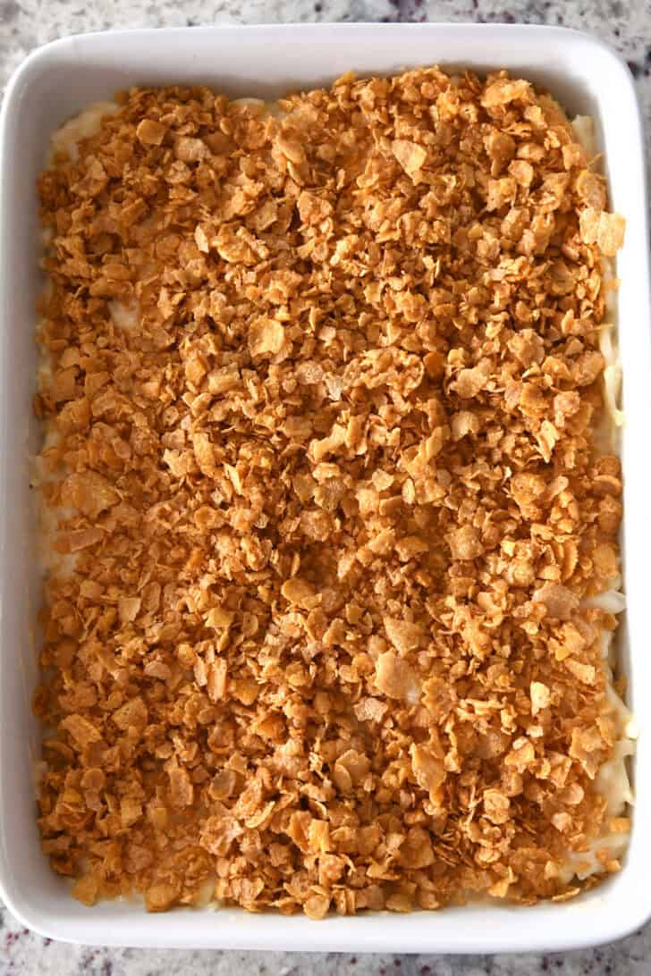 Top down view of cornflake-topped au gratin potatoes in a white dish.