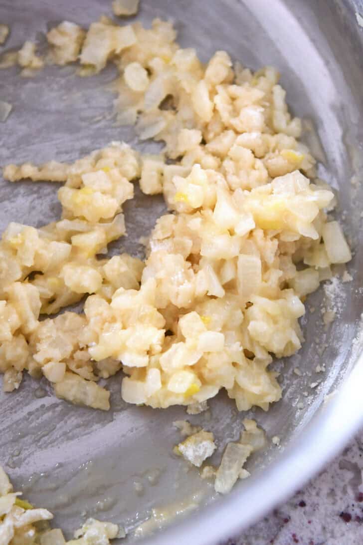 Top down view of sauteed onions in a pot.