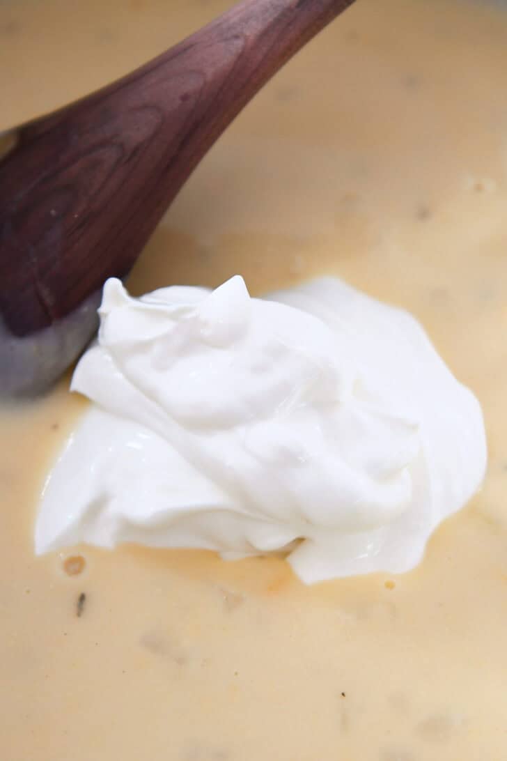 A large dollop of sour cream on top of a creamy sauce.