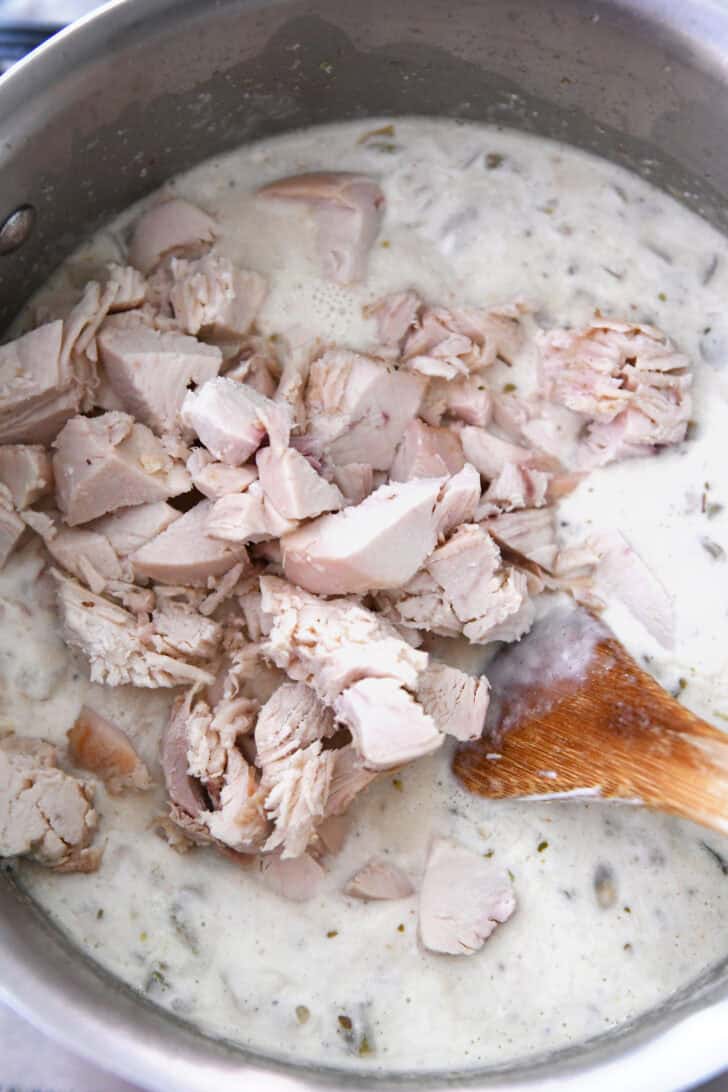 Top down view of an instant pot full of creamy white chili and chopped chicken.