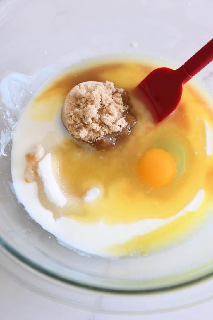 Glass bowl with brown sugar, milk, sugar, and egg.