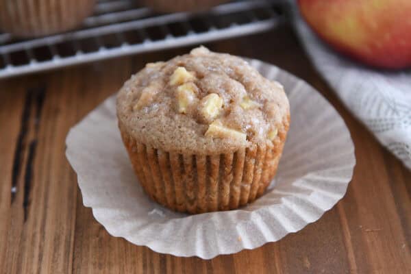 Unwrapped apple muffin on paper liner.
