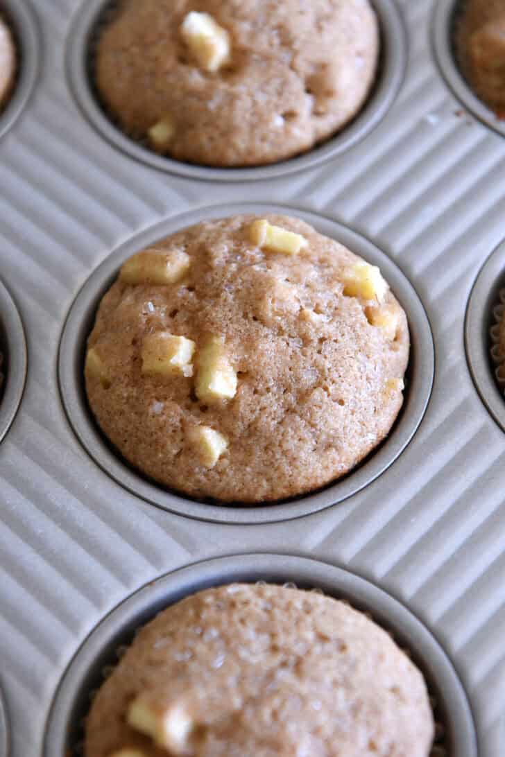 Baked apple cinnamon muffin in muffin tin.