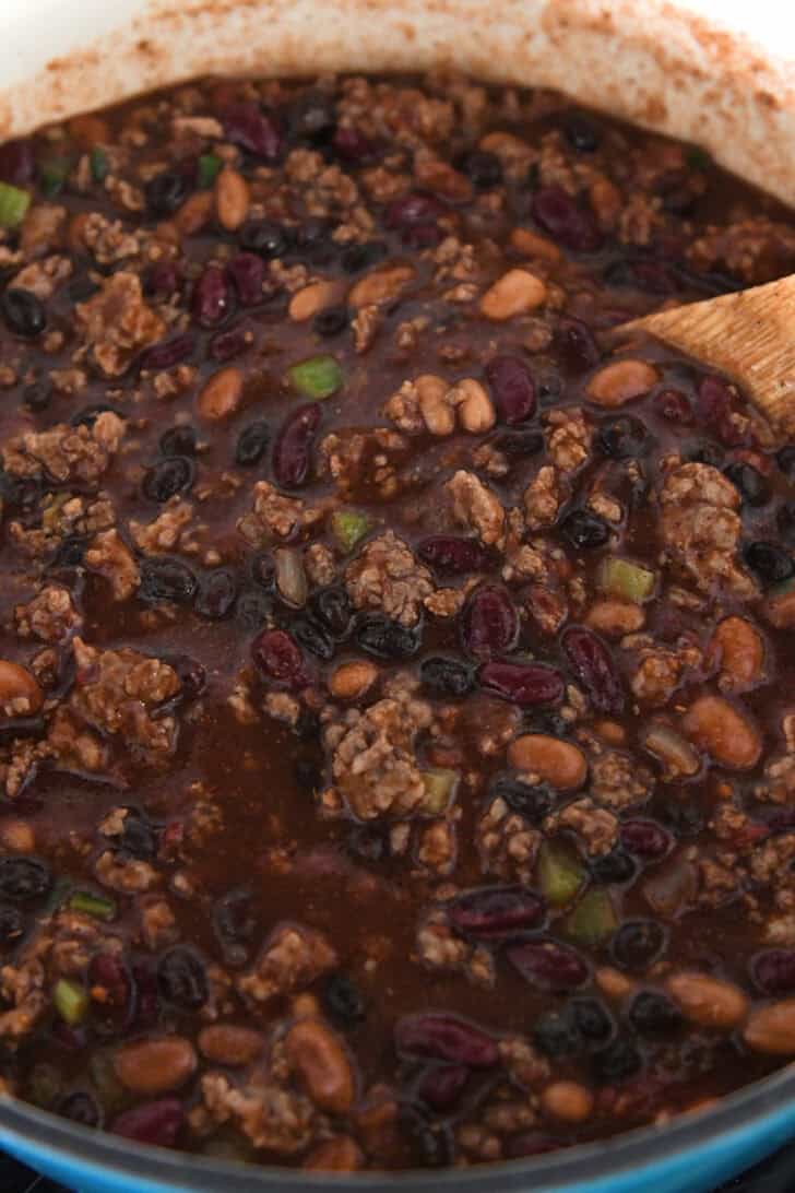 Tomato, bean and ground beef chili in cast iron pot.