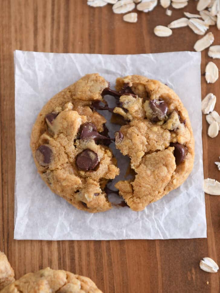 Pumpkin oatmeal chocolate chip cookie in half with melted chocolate chips.
