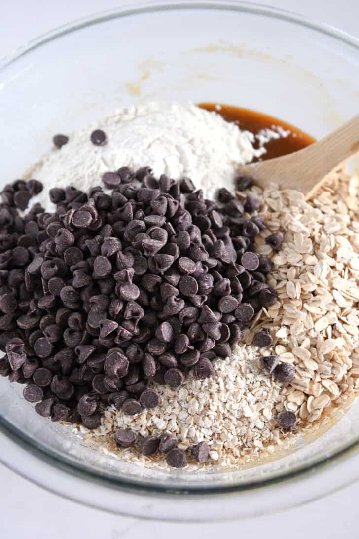 Glass bowl with flour, chocolate chips and oats.