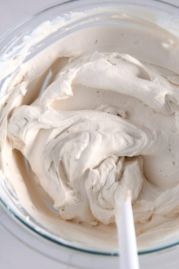Glass bowl filled with caramel whipped cream cheese frosting.
