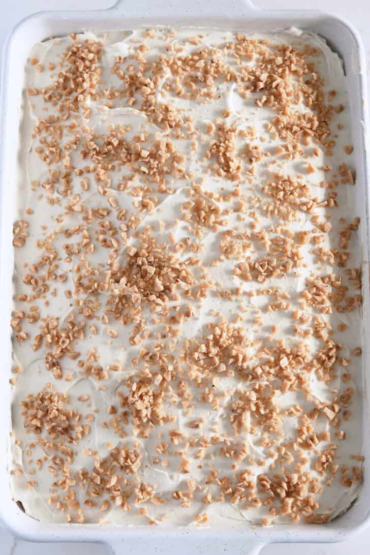 Top down view of pumpkin cake topped with whipped caramel cream frosting and toffee bits.