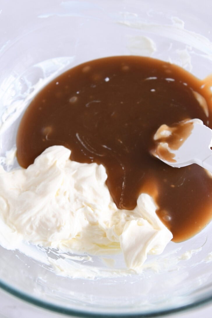 Glass bowl of whipped cream cheese and caramel sauce.