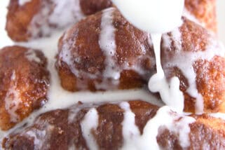 Spoon drizzling glaze over cinnamon bread.