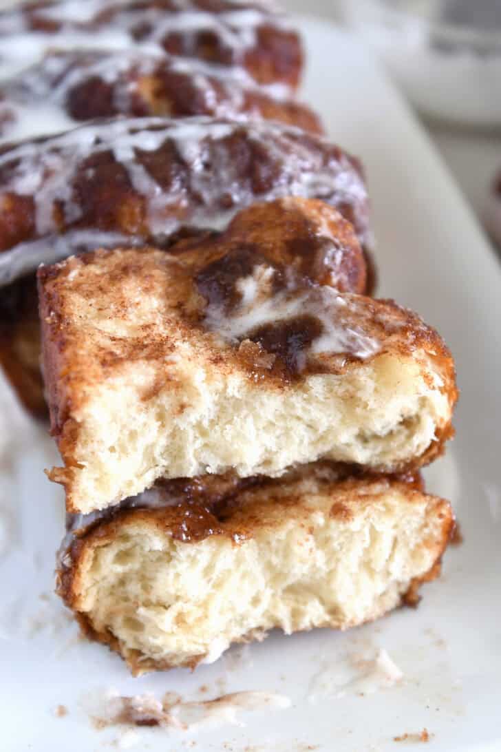 Two half slices of cinnamon bread on white platter with glaze.