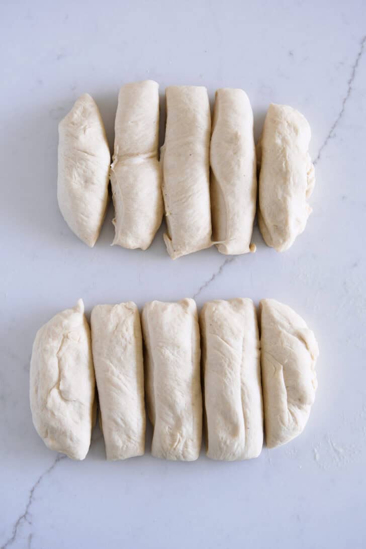 Two pieces of dough cut into five thick strips each.