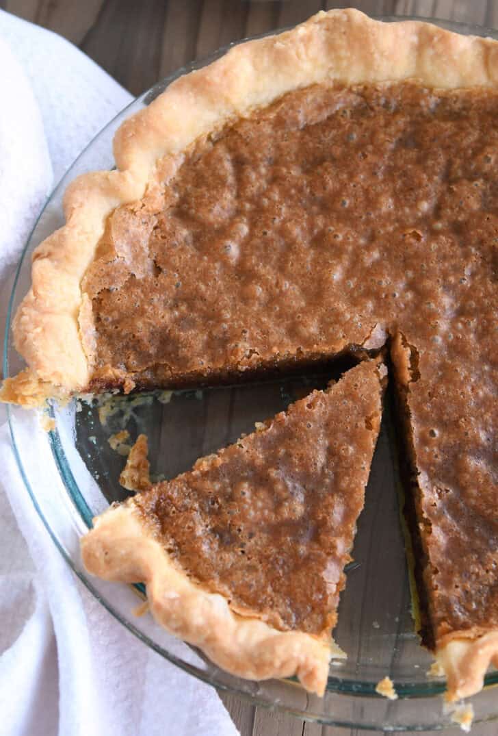 Top down view of a chocolate chip cookie pie with a slice cut out.