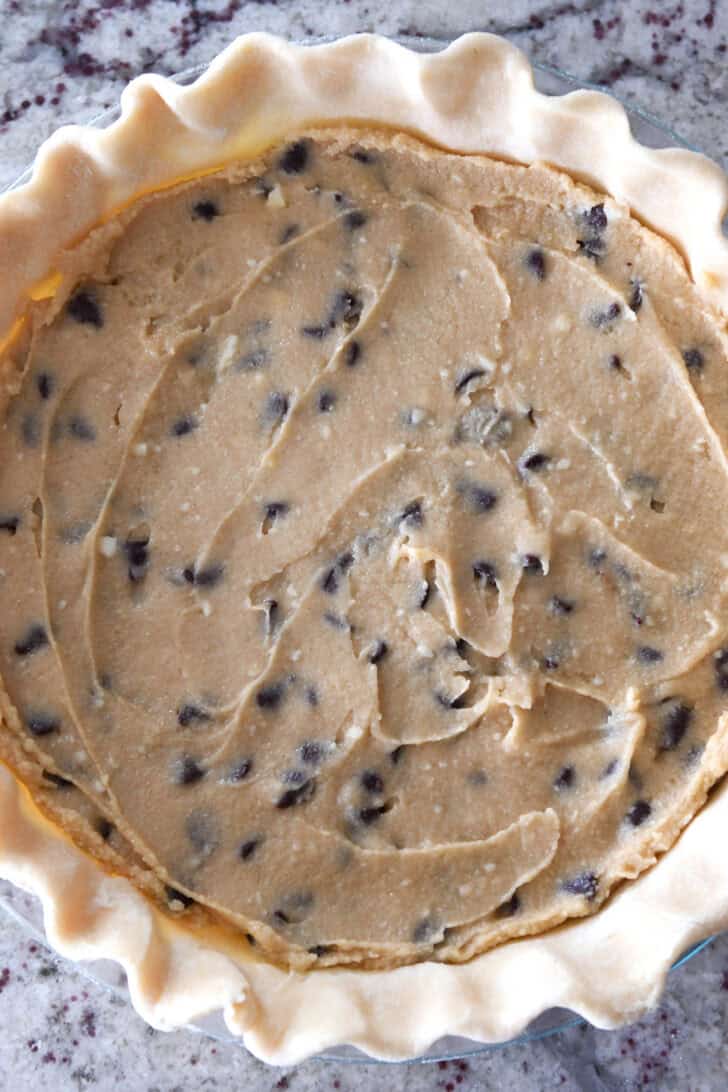 Top down view of an unbaked chocolate chip cookie pie.