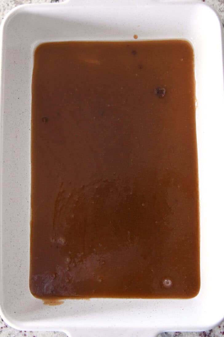 Top down view of a ceramic white dish with a cinnamon butter mixture in it.