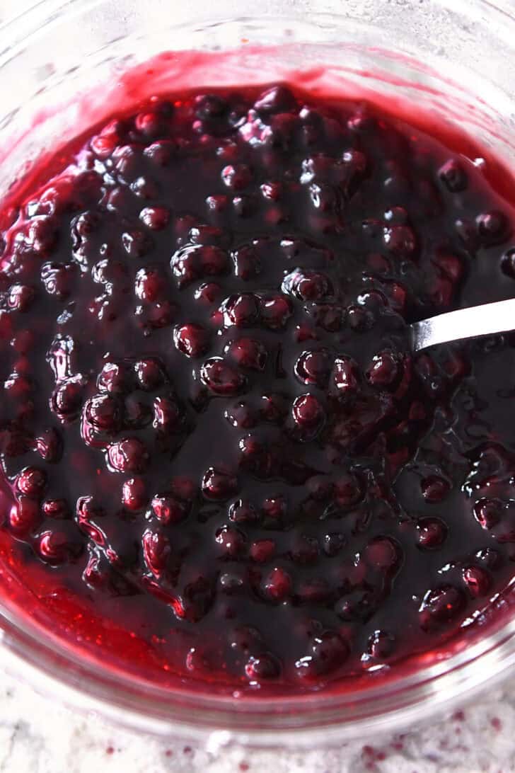 Top down view of a blueberry fruit sauce in a glass bowl.