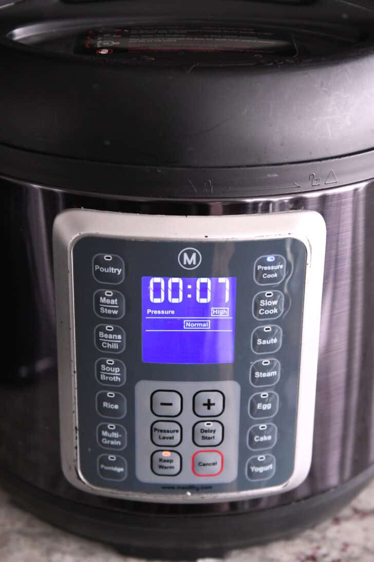 The front of an InstantPot with 7 minutes showing on the screen.