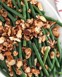 Top down view of steamed green beans with toasted almonds, garlic and shallots.