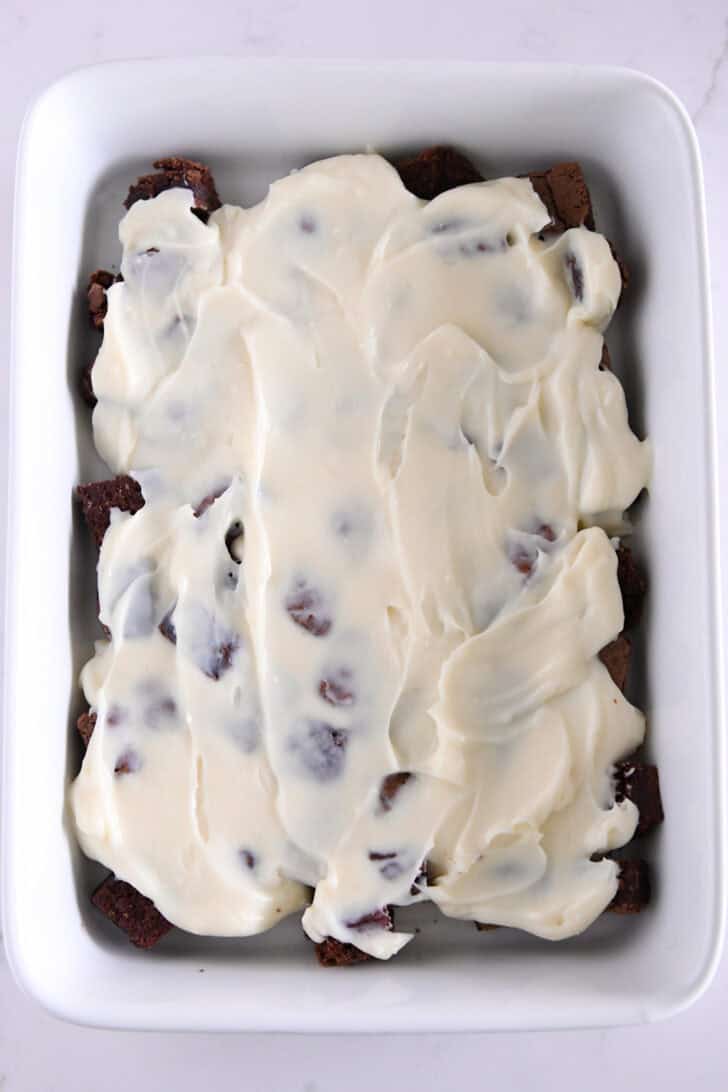 Pudding layer spread over top of brownie cubes in 9X13-inch white baking dish.