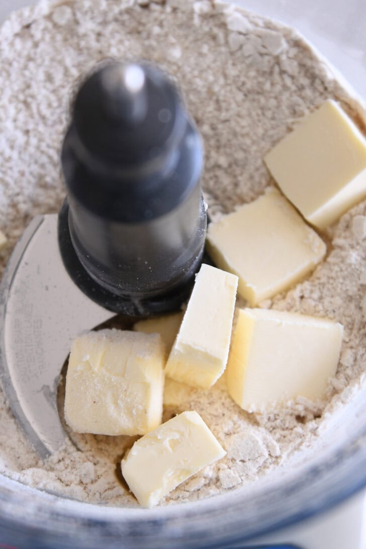 Butter cubes, flour and finely chopped pecans in food processor.