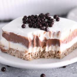 Bite taken out of chocolate pudding dessert on white plate.