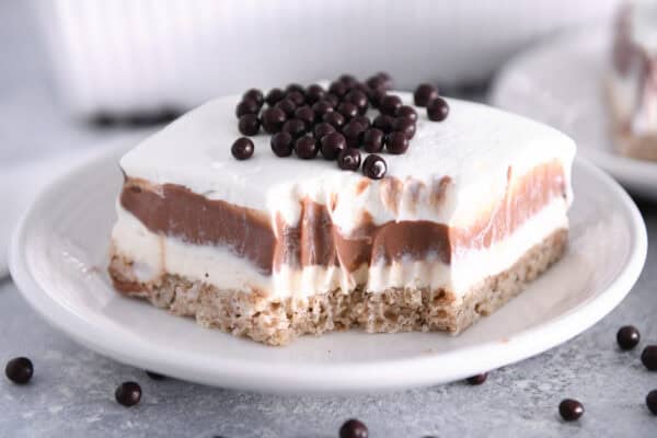 Bite taken out of chocolate pudding dessert on white plate.