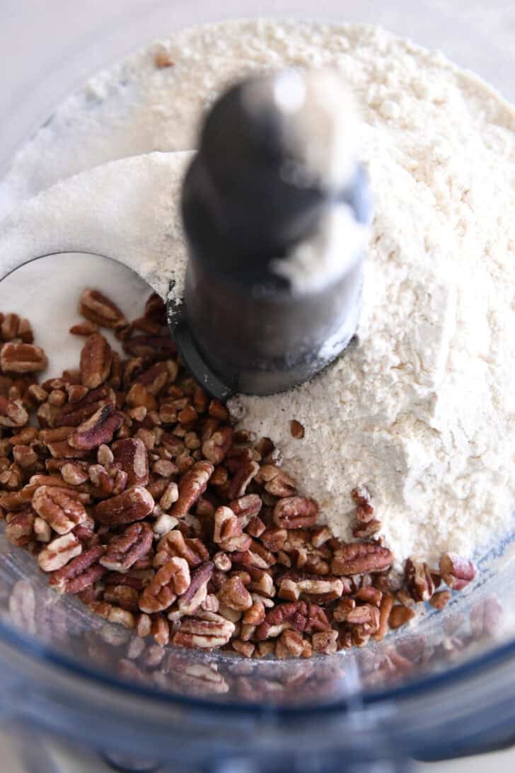 Pecans and flour in food processor with blade.