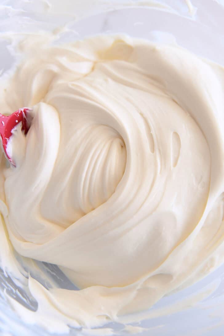 Creamy no-bake cheesecake batter in glass bowl.