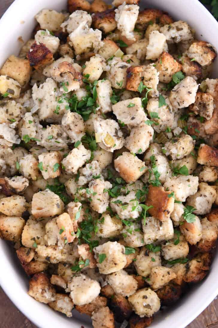 Top down view of baked stuffing and fresh parsley.