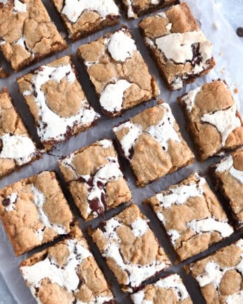 Top down view of golden brown s'mores cookie bars with fissures of gooey marshmallow and melted chocolate throughout each bar.