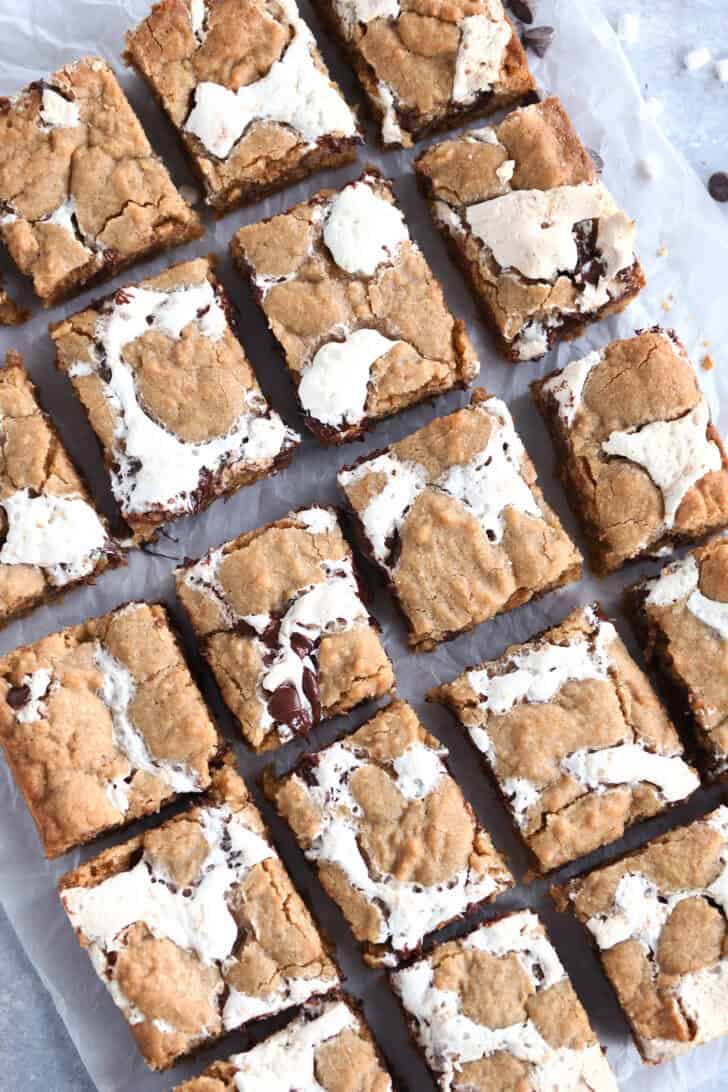 Top down view of golden brown s'mores cookie bars with fissures of gooey marshmallow and melted chocolate throughout each bar.