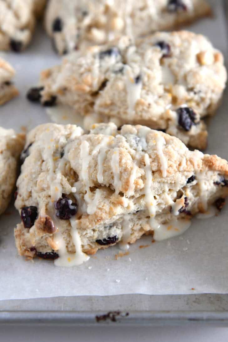 Baked cranberry orange scones drizzled with glaze.