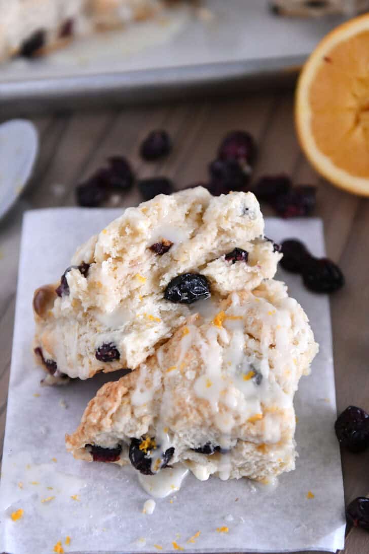Cranberry orange scone in half and drizzled with glaze.
