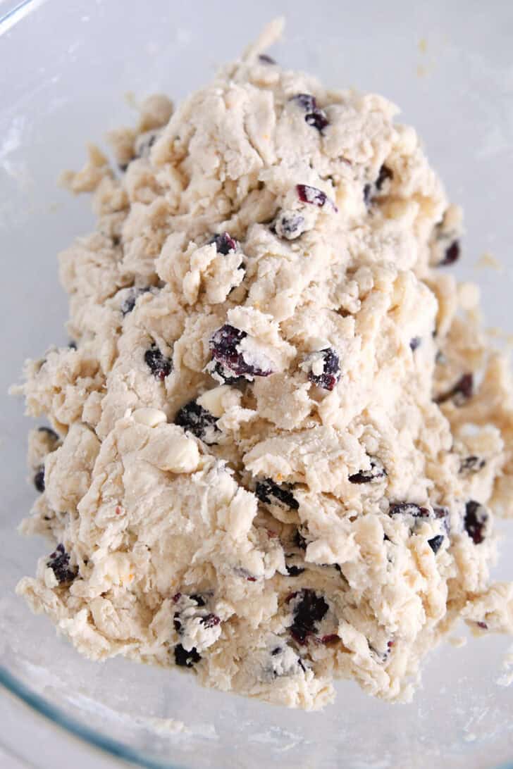 Bowl with mixed scone batter with dried cranberries and chocolate chips.