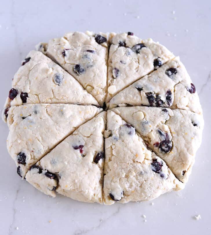Circle of scone dough cut into eight triangle pieces.