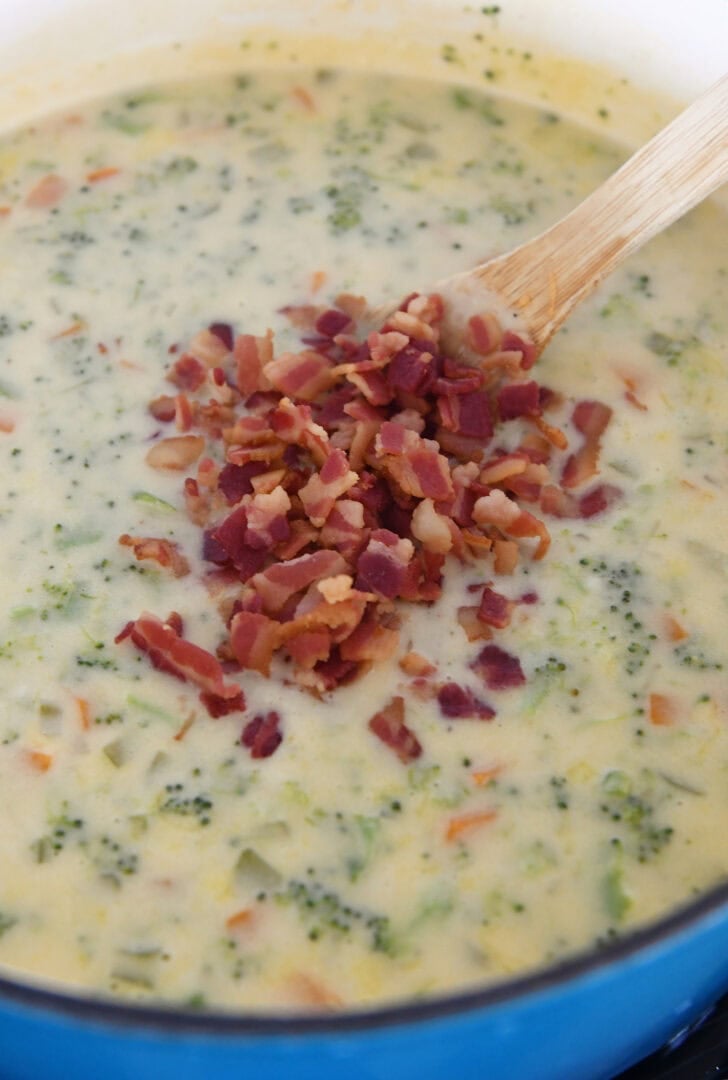 Soup pot with broccoli cheese soup and fried crisp bacon pieces on top.