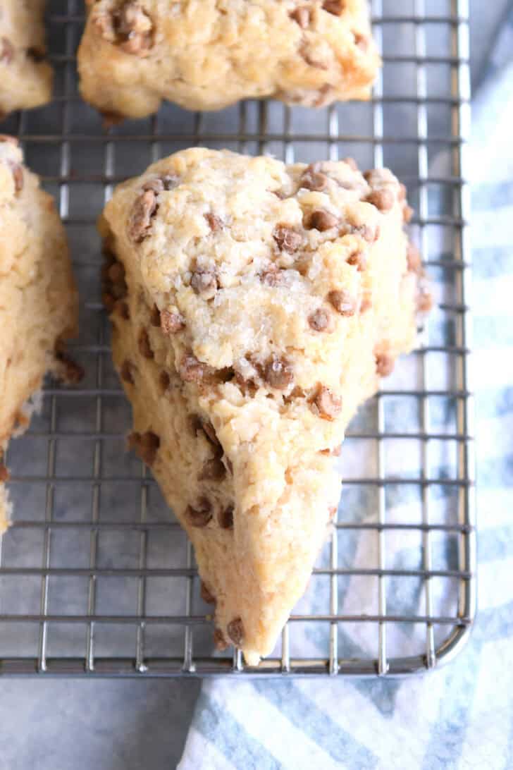 Top down view of a baked cinnamon chip scone on a wire cooling rack.