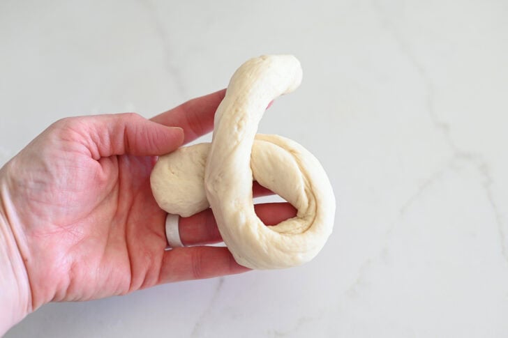 Forming breadstick knot by twisting breadstick ends one over the other.