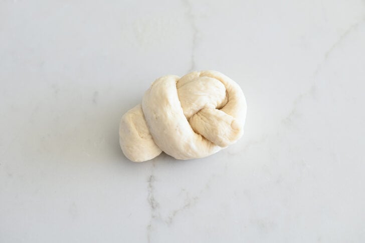 Breadstick dough knot on white counter.