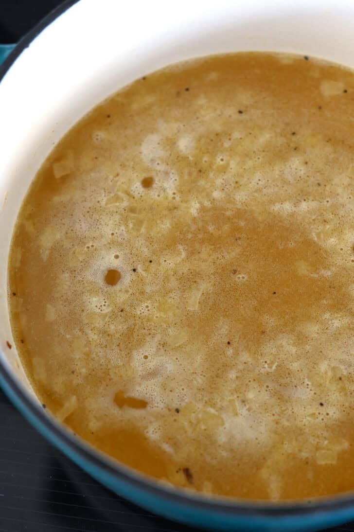 Chicken broth in cast iron pot for rice pilaf.